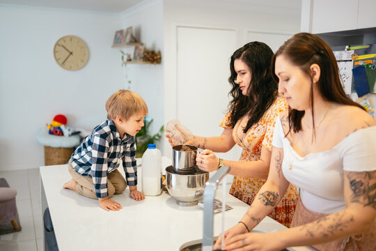 Little boy cooking with his moms at home