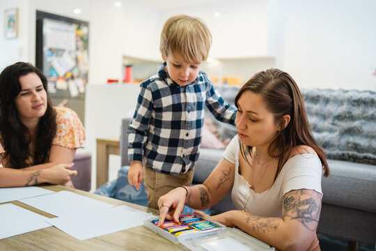 Little boy drawing at home with his mothers