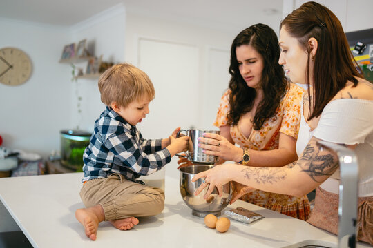 Child helping their mothers bake a cake