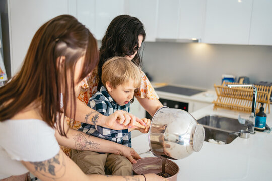 LGBT family baking a cake at home