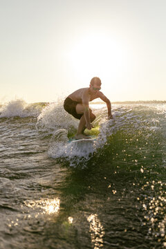Man on wakesurf in sunset light.