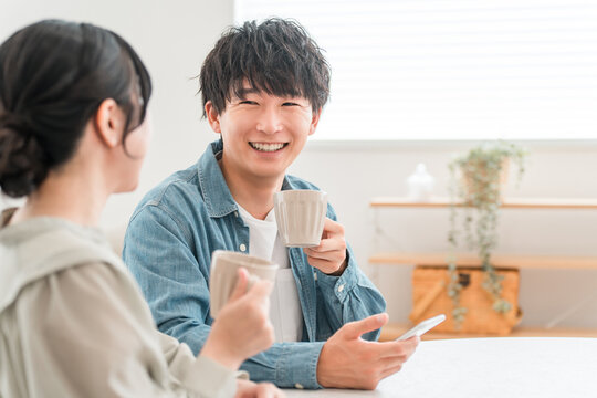 Couple having a conversation while drinking hot drinks at the dining table