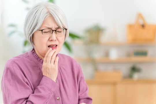 口内炎,口唇ヘルペスで唇を痛がるグレイヘアのシニア女性