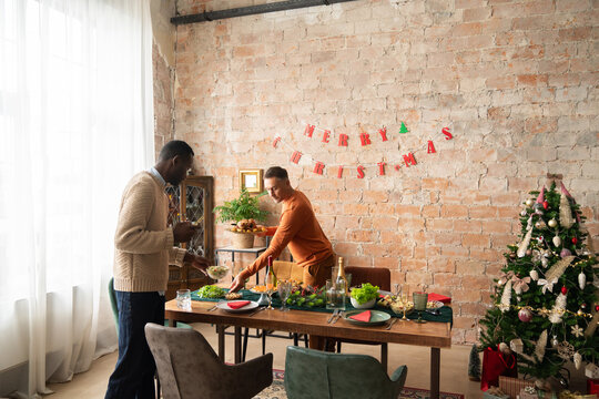 People setting table for Christmas celebration
