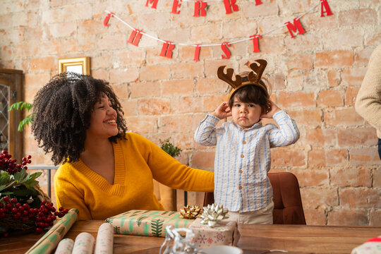 Child in reindeer headband next to his mother