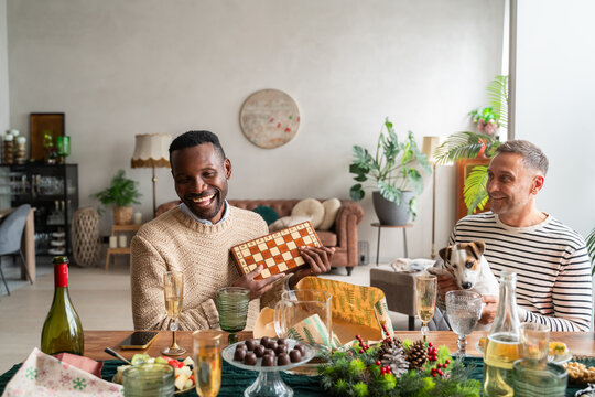 Happy man unwrapped a gift at Christmas dinner