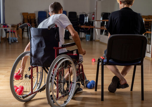 Faceless Young disabled paralympic athlete plays boccia in wheelchair