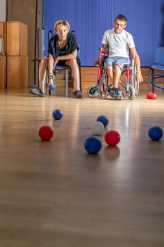 Young disabled paralympic athlete plays boccia in wheelchair