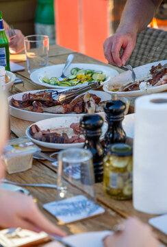 Family dinner table with barbecued meat and salads. 