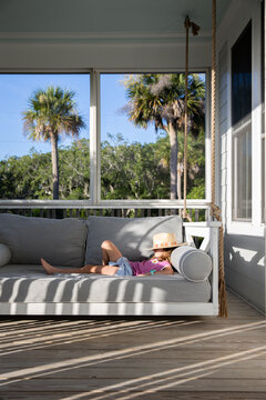 Girl relaxing on a back porch swing