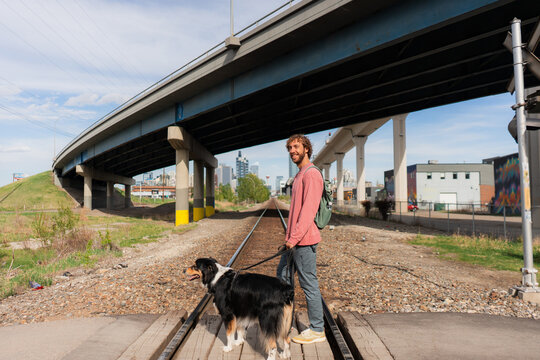 Man crossing the railway walking on the dog in Calgary, Canada 