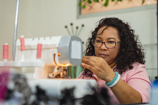 Focused seamstress at sewing machine