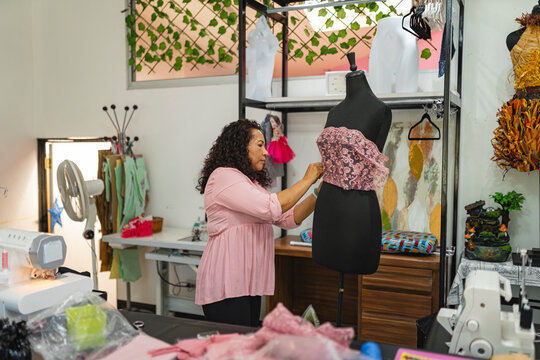 Designer adjusting garment on mannequin