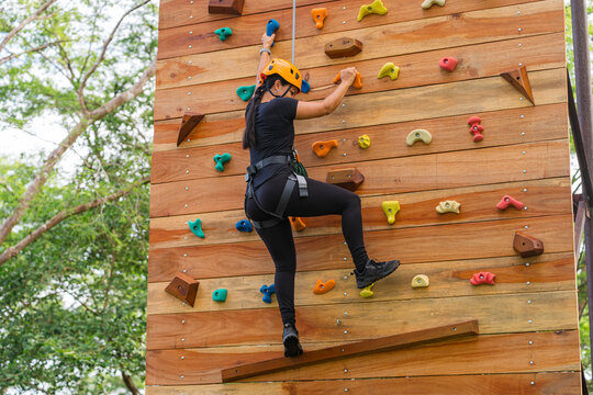 Woman climbing adventure wall