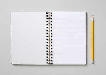 Top view of open spiral notebook with lined pages and a yellow pencil on gray background