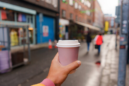 Takeaway cup of coffee on the background of Dublin street 