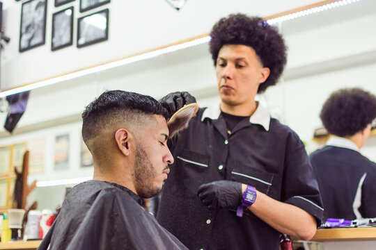 Barber using neck duster on client