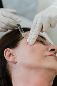 Doctor injecting botulinum toxin into patient's face