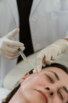 Doctor injecting botulinum toxin for wrinkles treatment