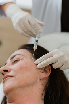 Doctors injecting botulinum toxin into patient's face
