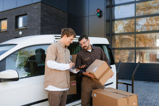 Men unload parcels from the car