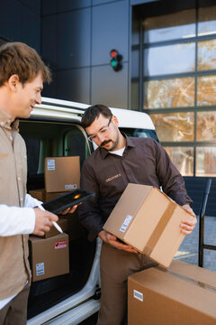 Men unload parcels from the car