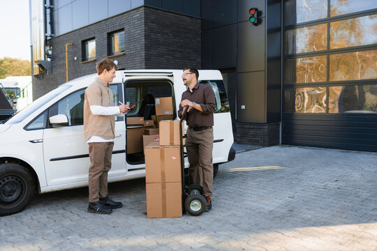 Men unload parcels from the car