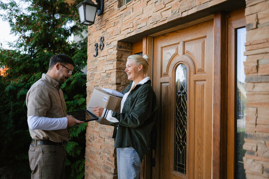 The postman delivers the parcel to the customer