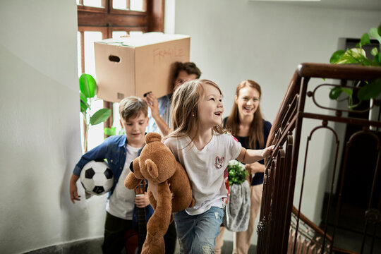 Happy family with kids moving into new apartment stairwell