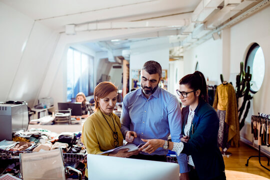 Team of fashion designers reviewing plans in modern studio
