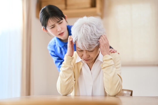 介護で塞ぎ込むアジア人シニア女性