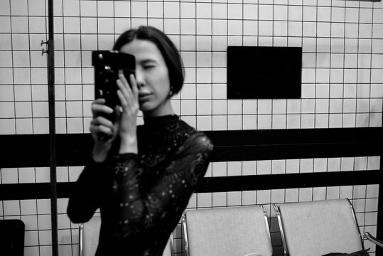 Young woman filming with a vintage camera - out of focus