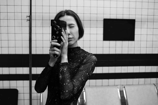 Young woman filming with a vintage camera