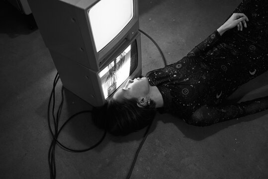 Woman lying close to old TV