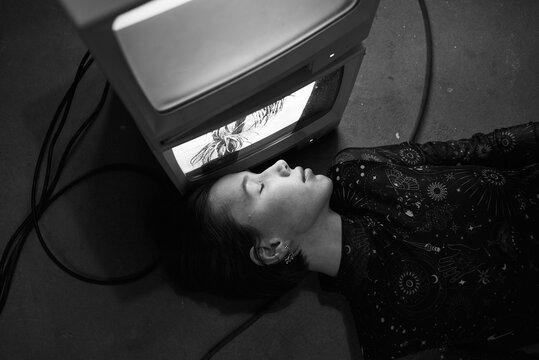 Woman lying close to old TV