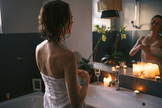 Woman in Bathroom with Towel and Candles