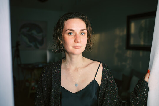 Woman with Wet Hair in Cozy Outfit Standing in Soft Light
