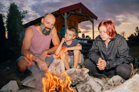 Family Sitting at Campfire
