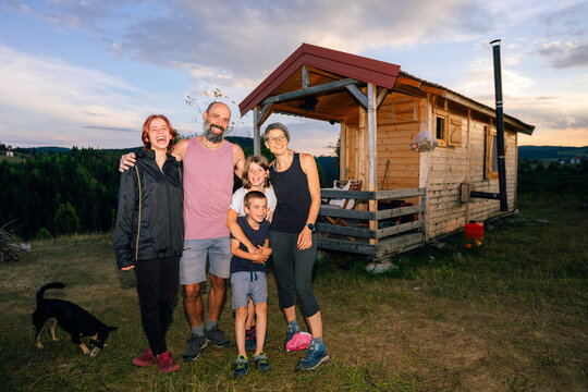 Happy Family with a Dog in front of their Home Portrait