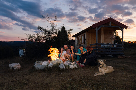 Family with a Dog Having a Light Dinner in Backyard