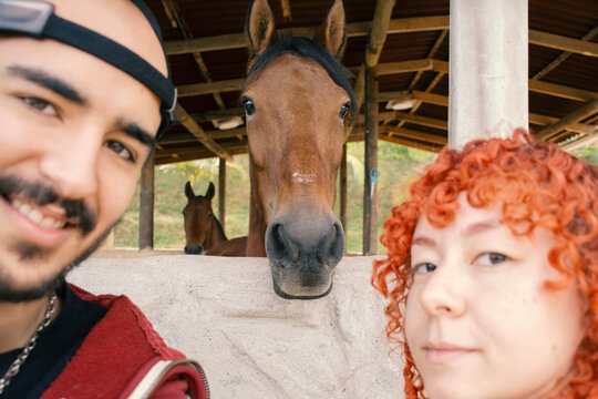 Man and woman's selfie with horse and mare