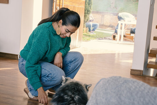 Latin woman knelt to pet huskey