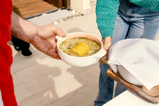 holding a bowl of ajiaco soup