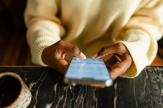 A woman uses a mobile phone in a cafe