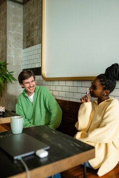 A man and a woman are talking in a cafe