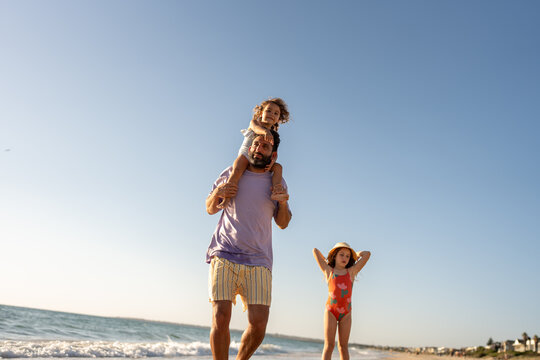 A family walking and together on the beach at sunset time.