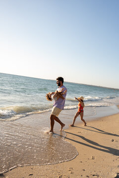 A family walking and together on the beach at sunset time.