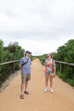 Two people chat on a scenic trail bordered by greenery in Melbourne