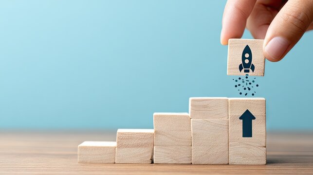 Hand placing rocket on wooden steps symbolizing growth and business success