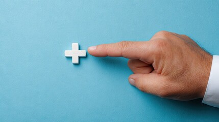 Hand pointing at white plus symbol on blue background healthcare concept